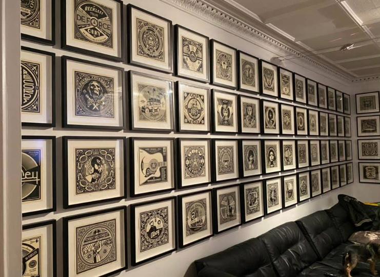A large collection of matching framed prints hung across a wall